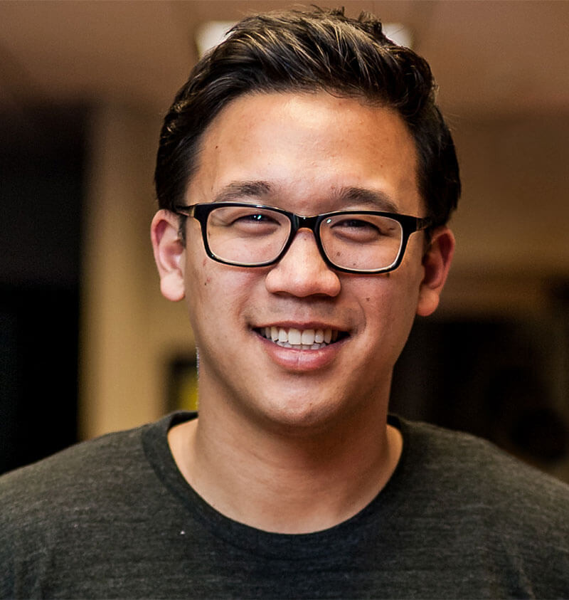 Headshot photograph of Alex Sheen a young Asian male with black glasses and a smile