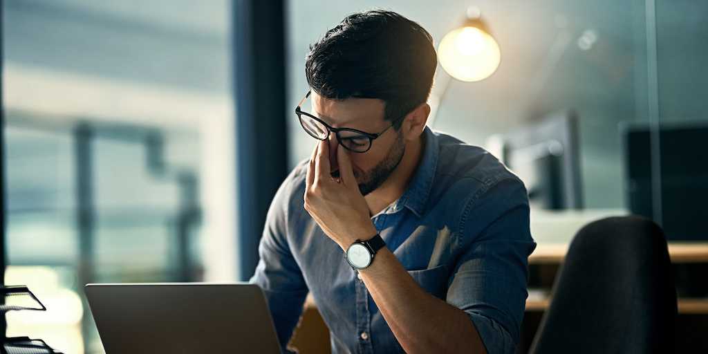 Shot of a young businessman experiencing stress during a late night at work