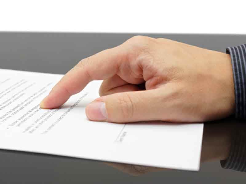 Hand pointing to line on a contract