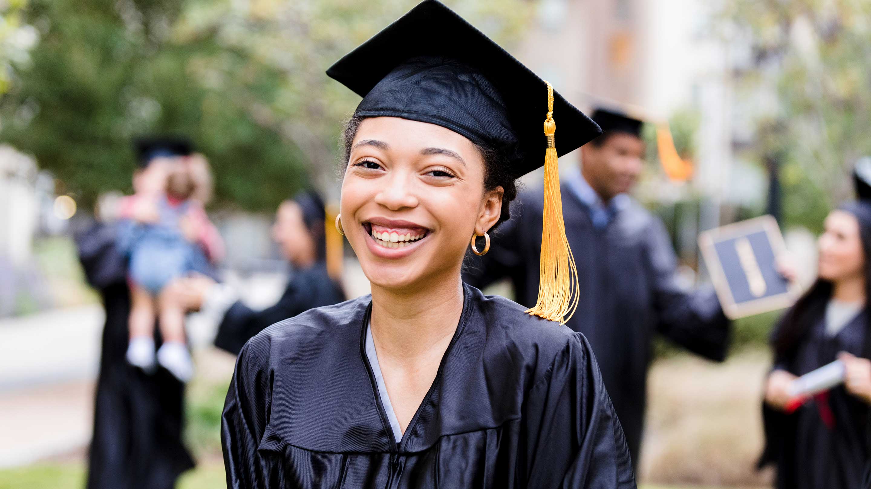 After graduation ceremony, woman smiles for photo