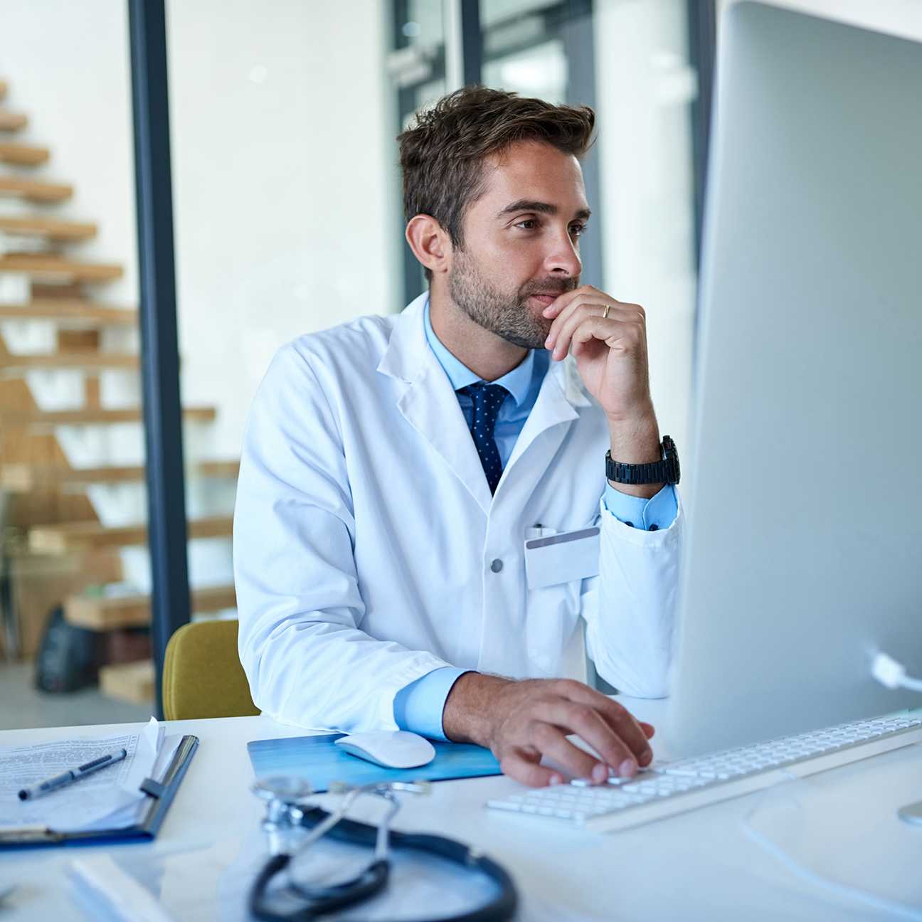 Doctor looking at computer while taking an online course.