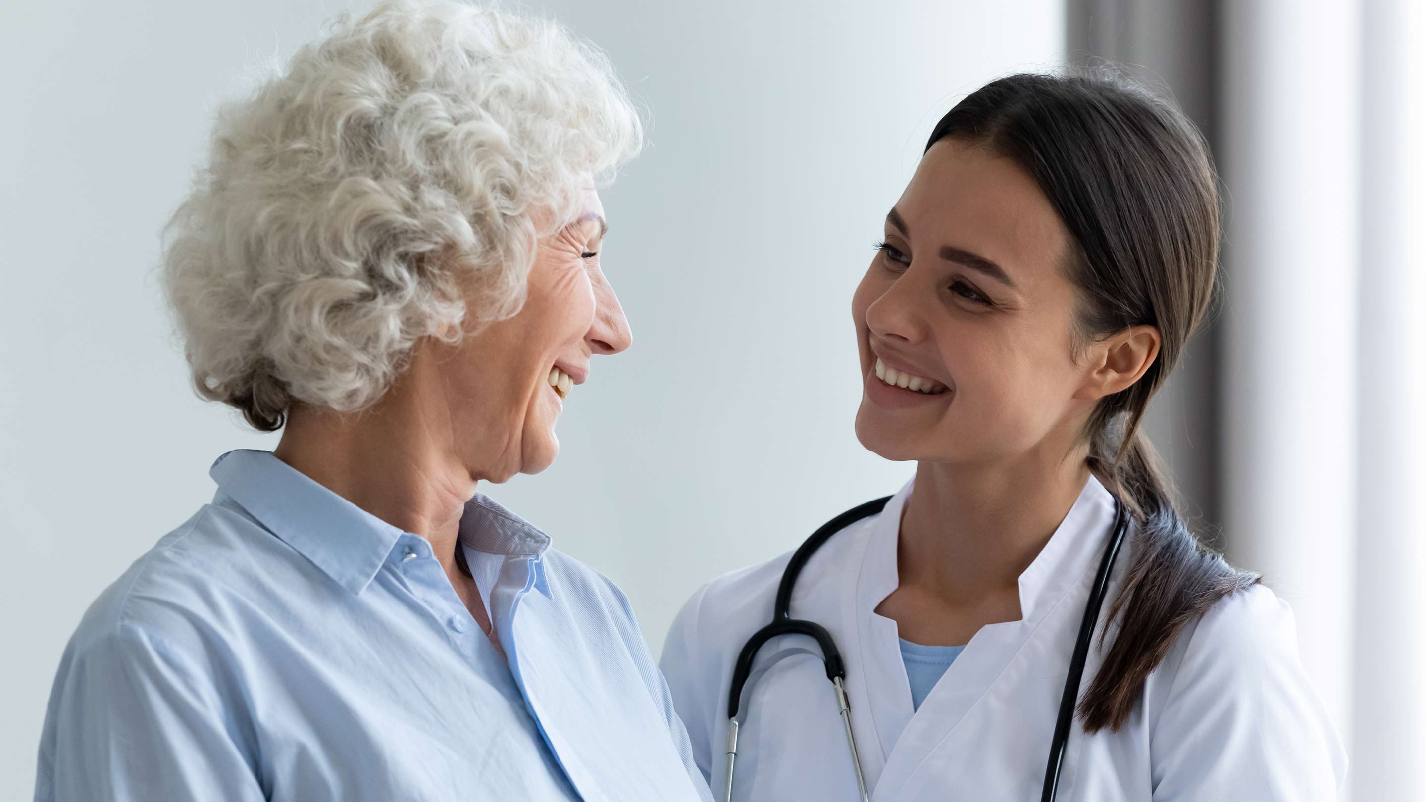 Smiling young female doctor assisting an elderly patient.