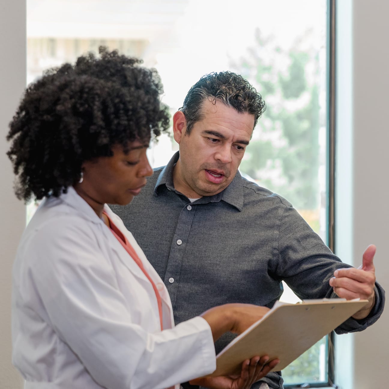 Image of a doctor showing notes to a non-physician coworker.