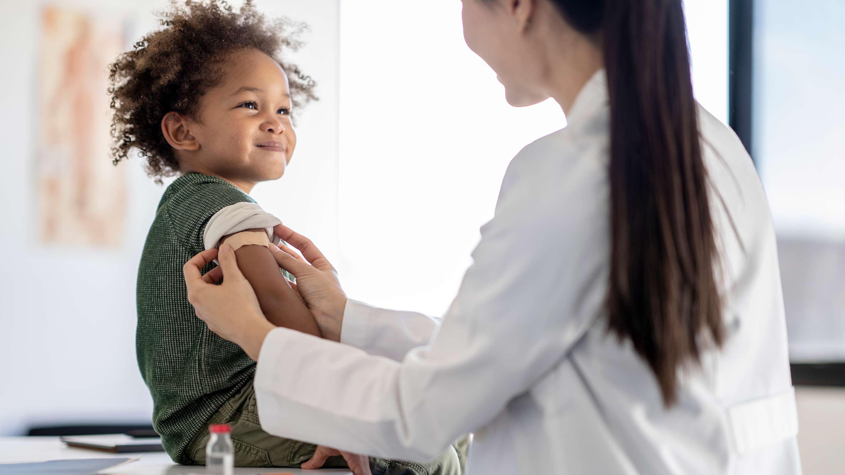 Doctor and cute child preparing to give a shot.