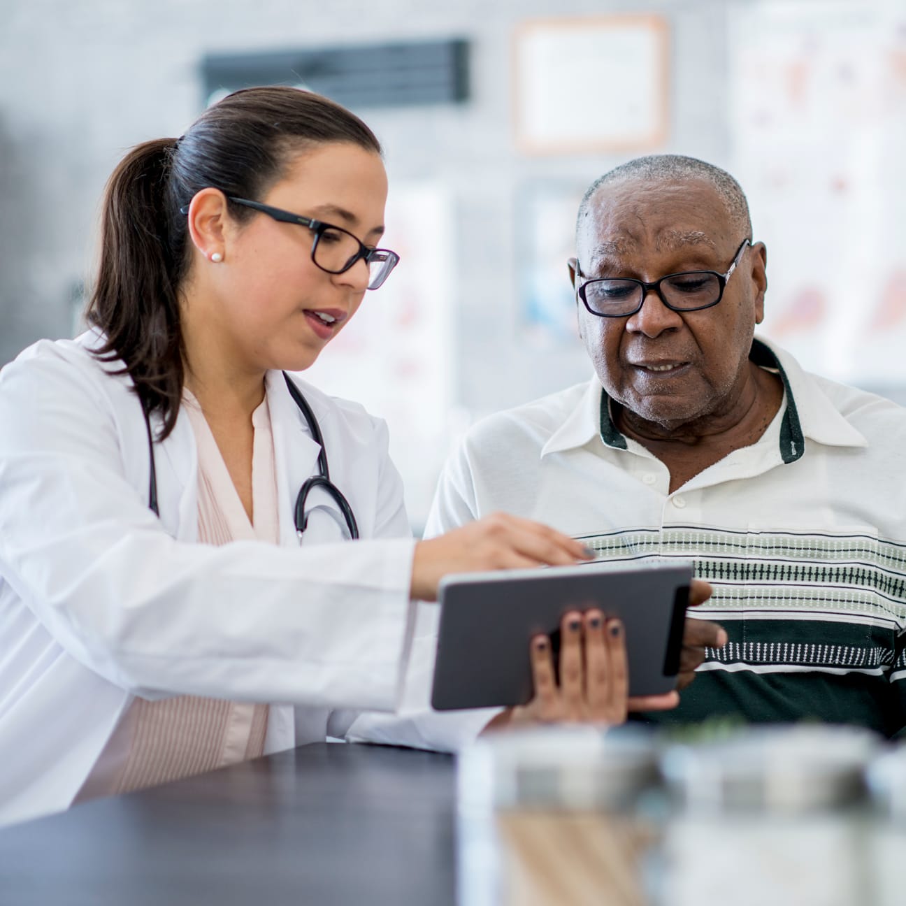Image of a senior man patient with his female doctor using a tablet computer.