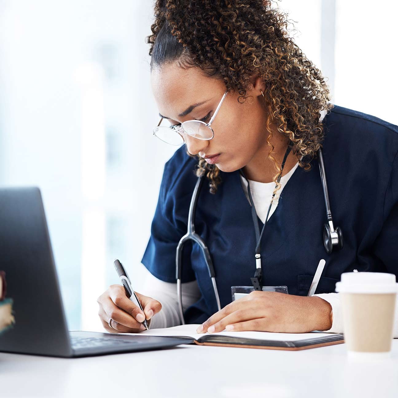 female doctor studying with her laptop and coffee