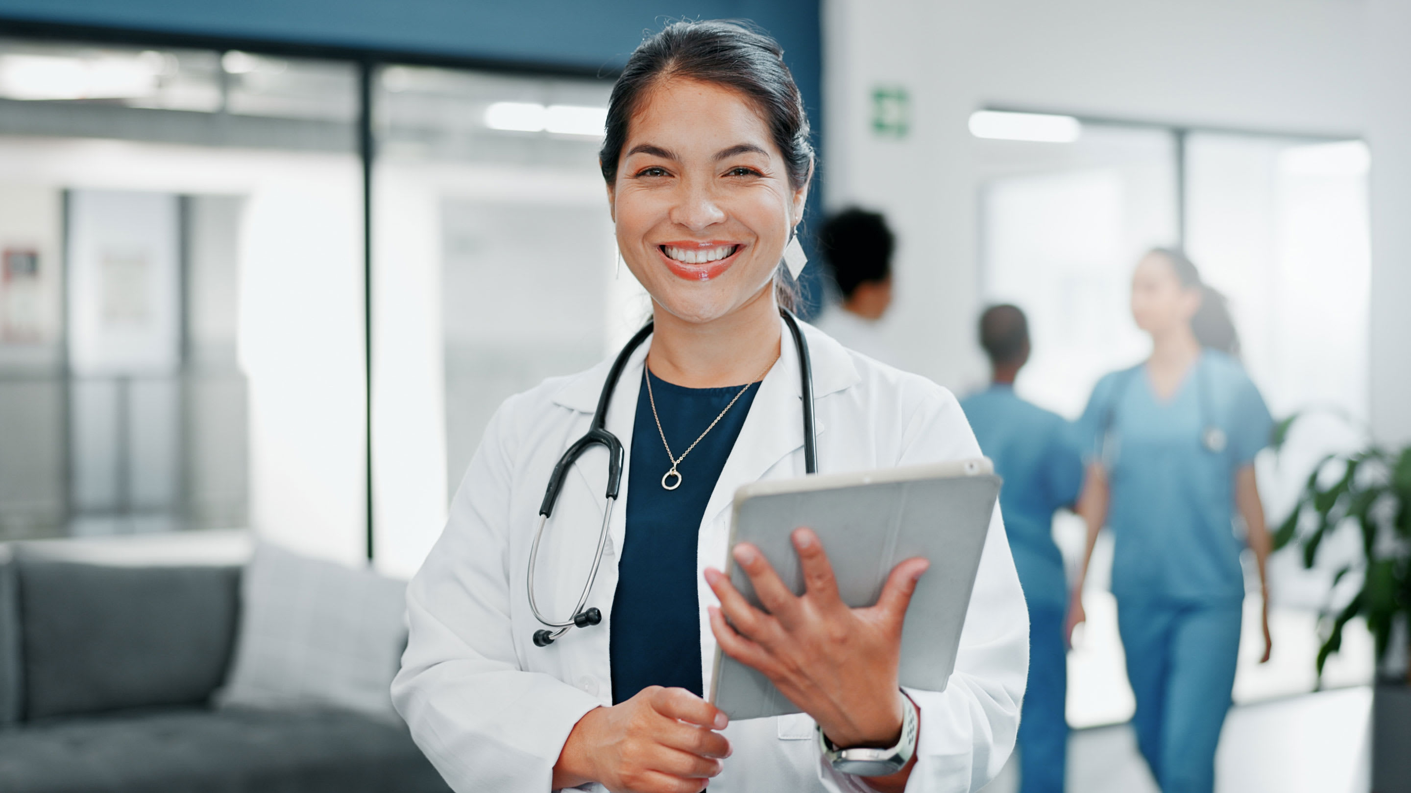 Image of smiling female medical professional in a hospital setting.