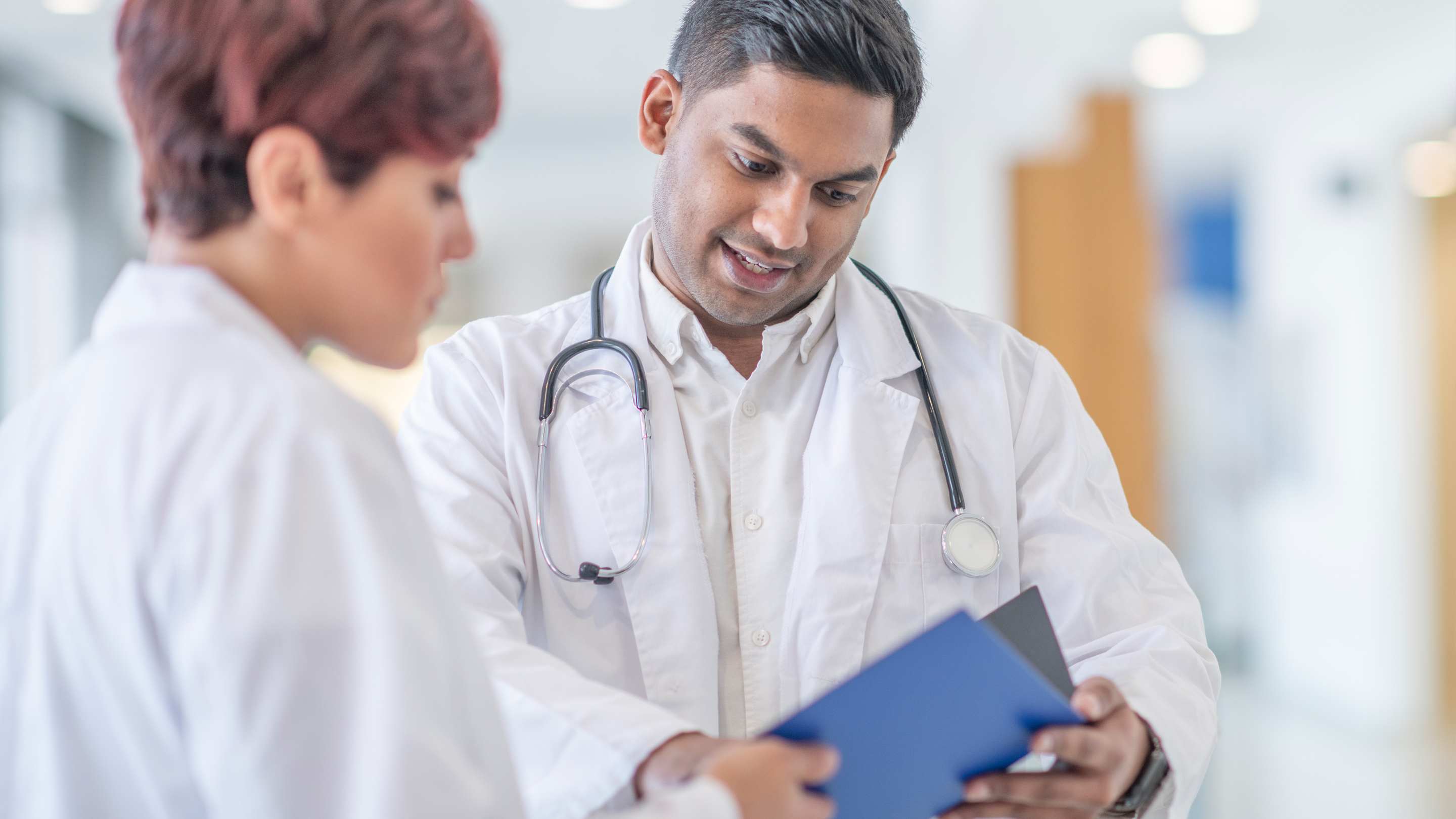 Two doctors consults over a patient file.