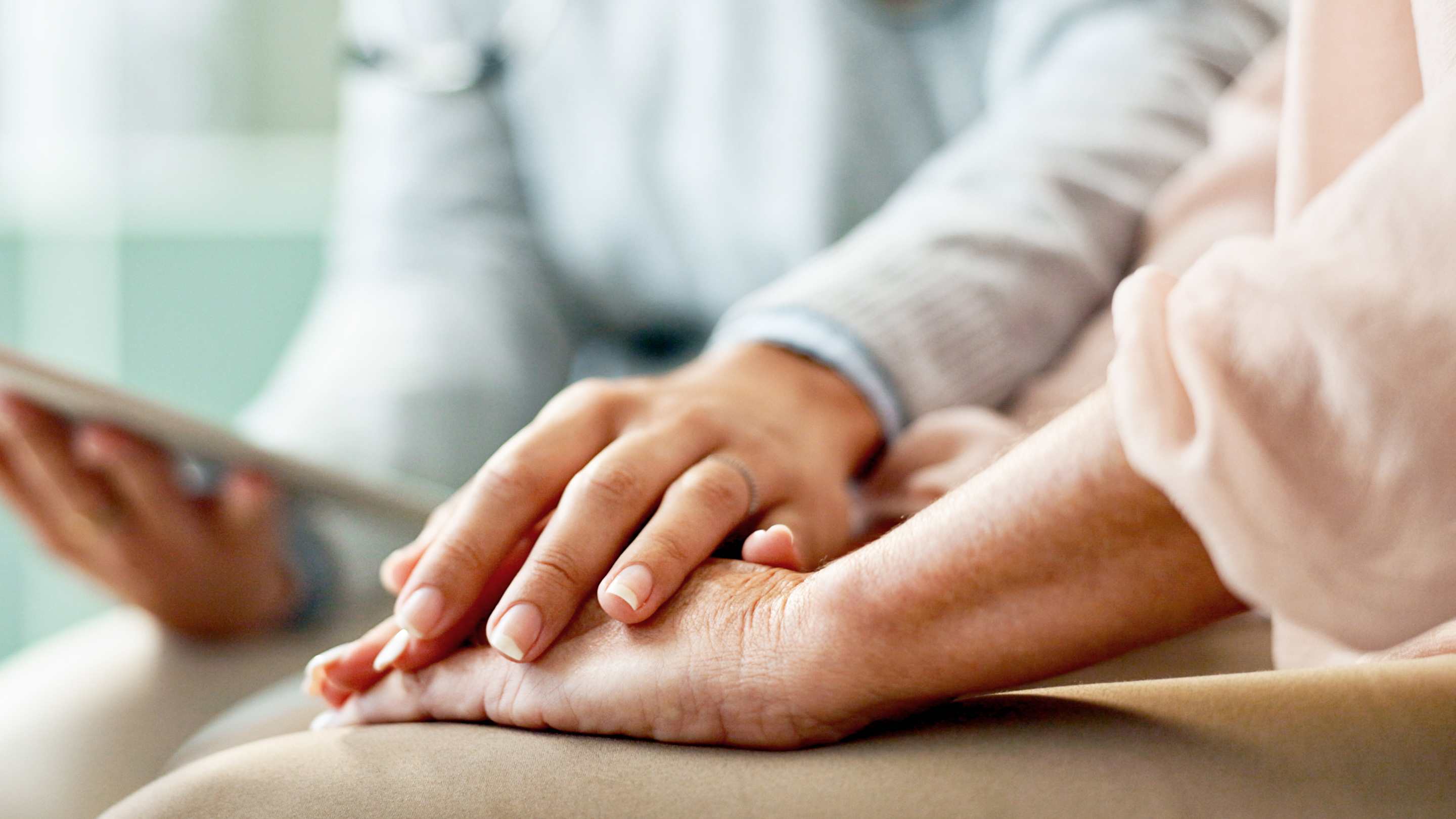 Physician holding hands with a patient