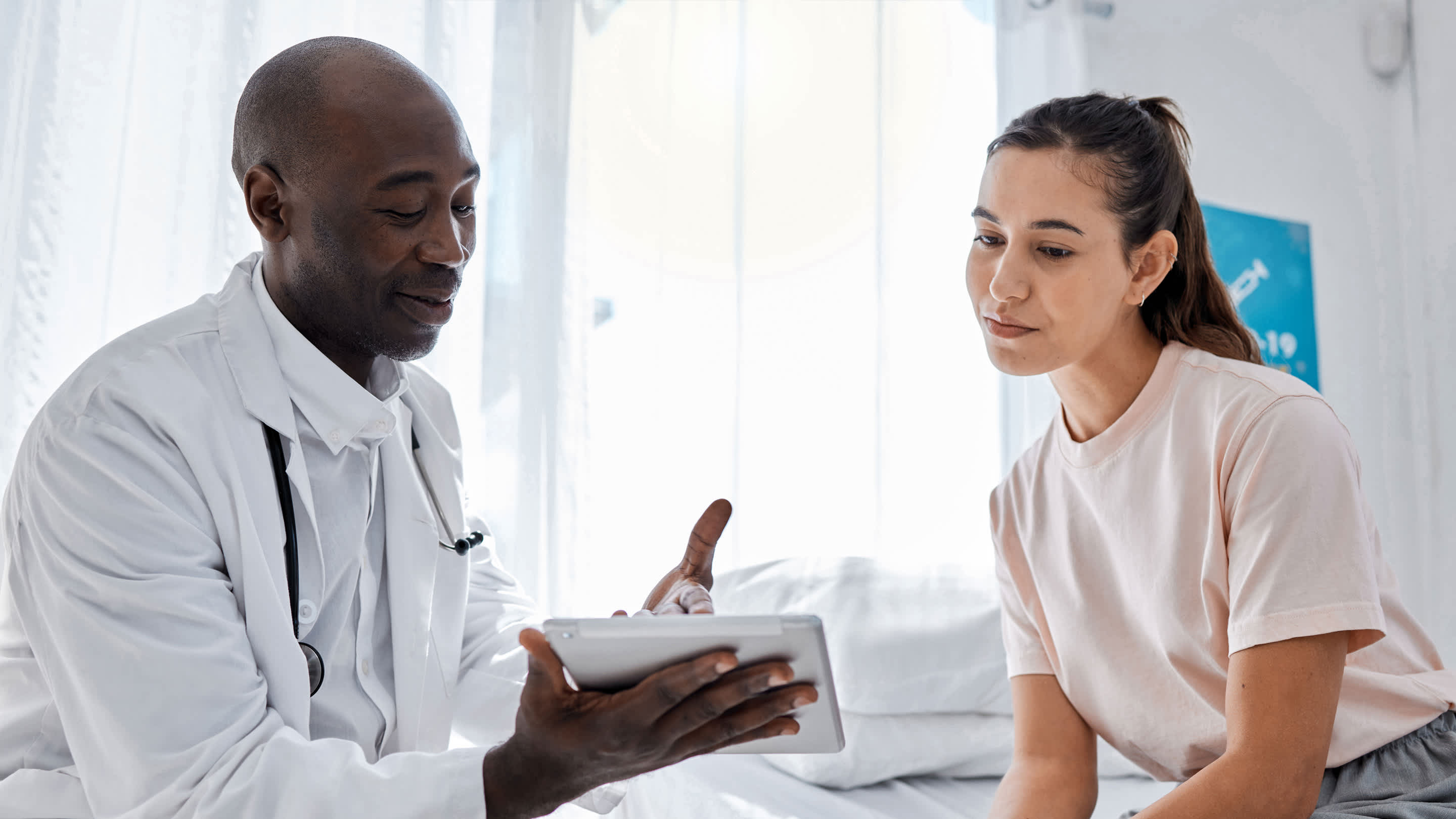 Physician reviews information on a tablet with a patient