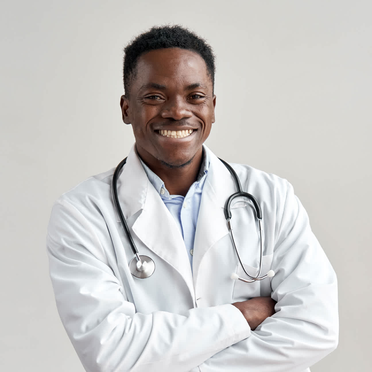 Happy young doctor, smiling with arms crossed.
