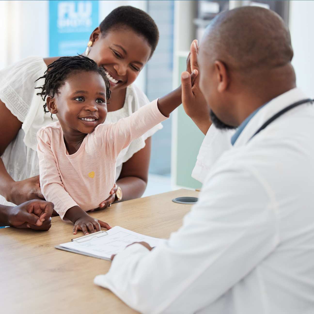 Family medicine—Family physician meeting with a child and parents during a multigenerational clinic visit.