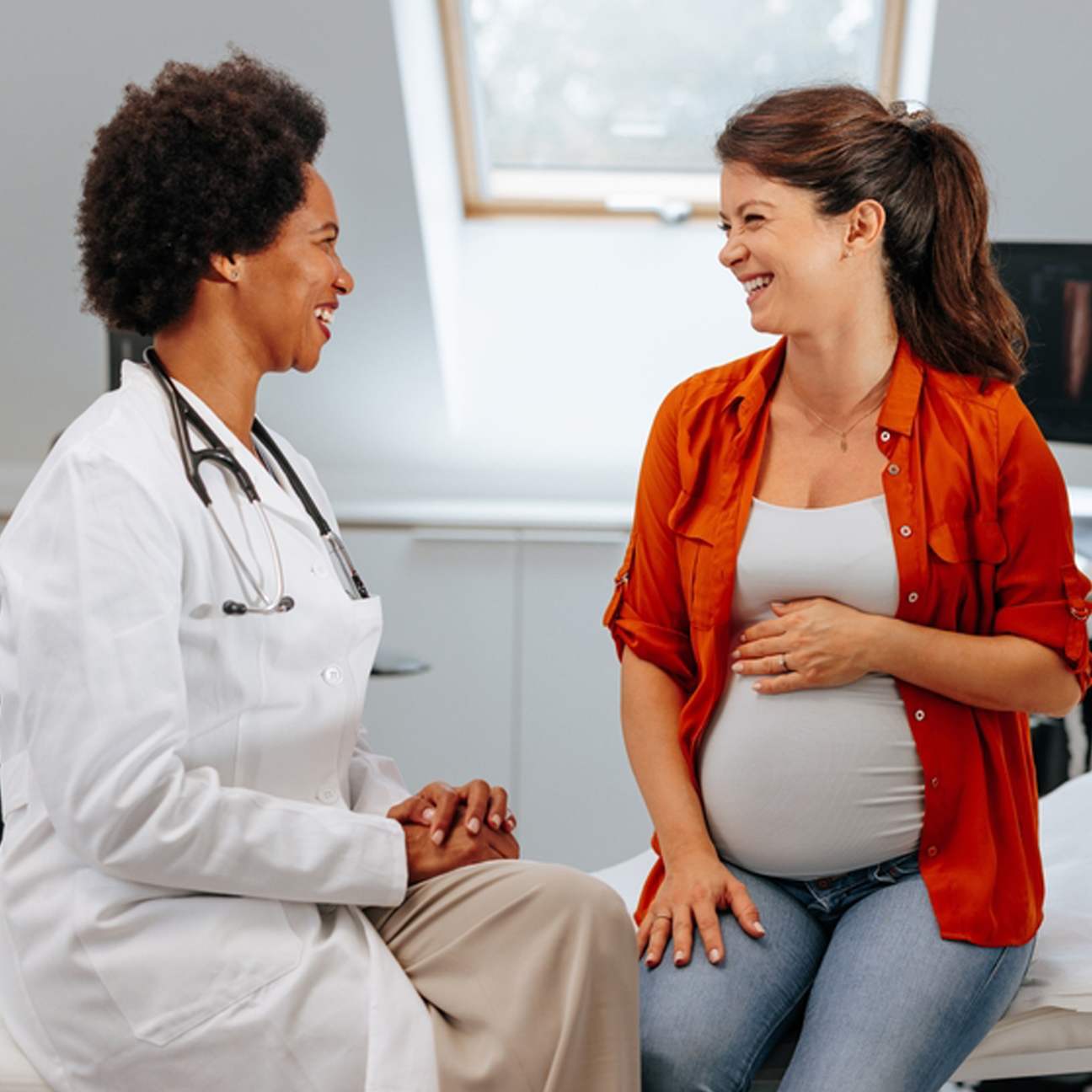 happy pregnant patient meeting with a female doctor.