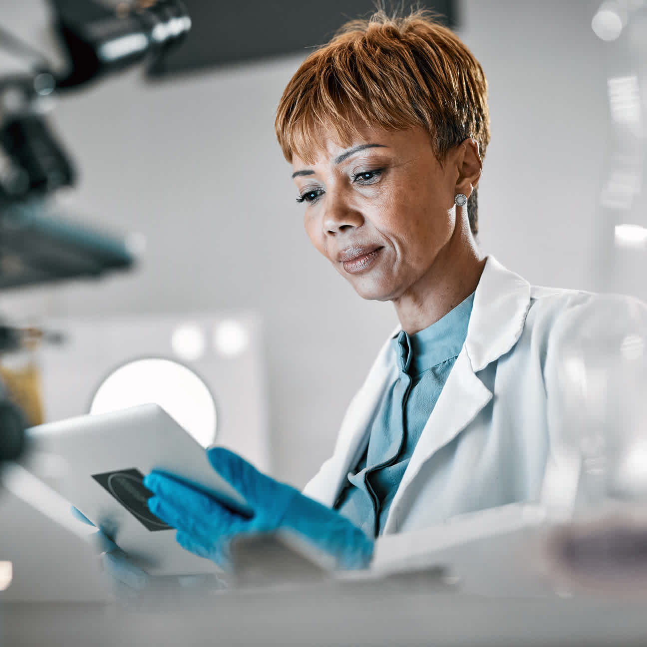 Medical researcher reviewing data on a tablet in a clinical research lab.