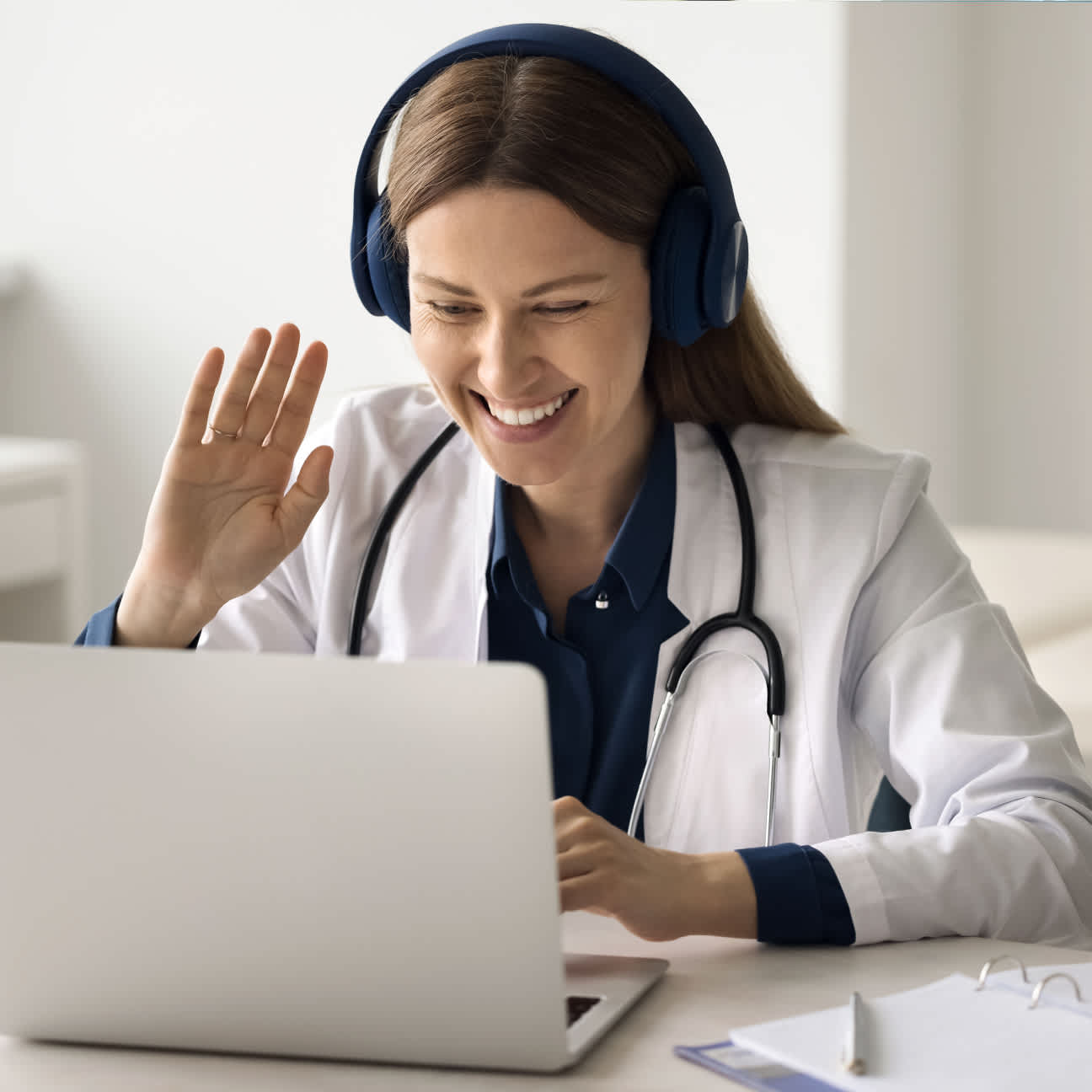 Happy female doctor smiling and waving on a virtual meeting