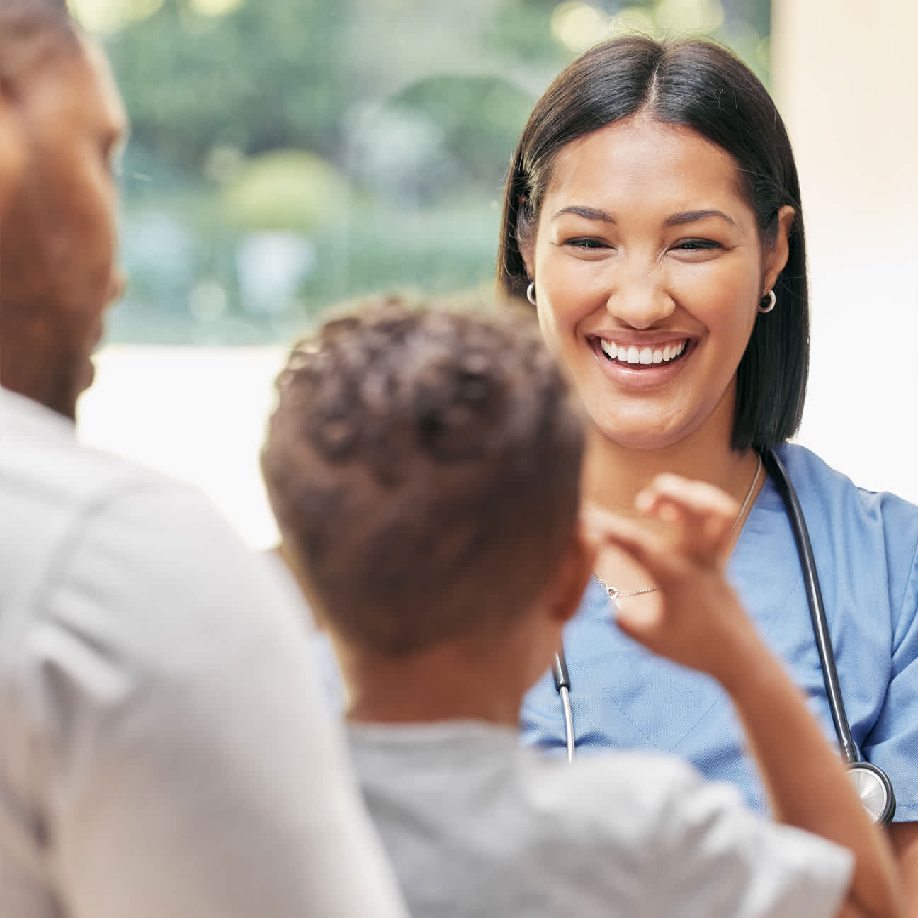 Father, child and physician talking and smiling during a consultation