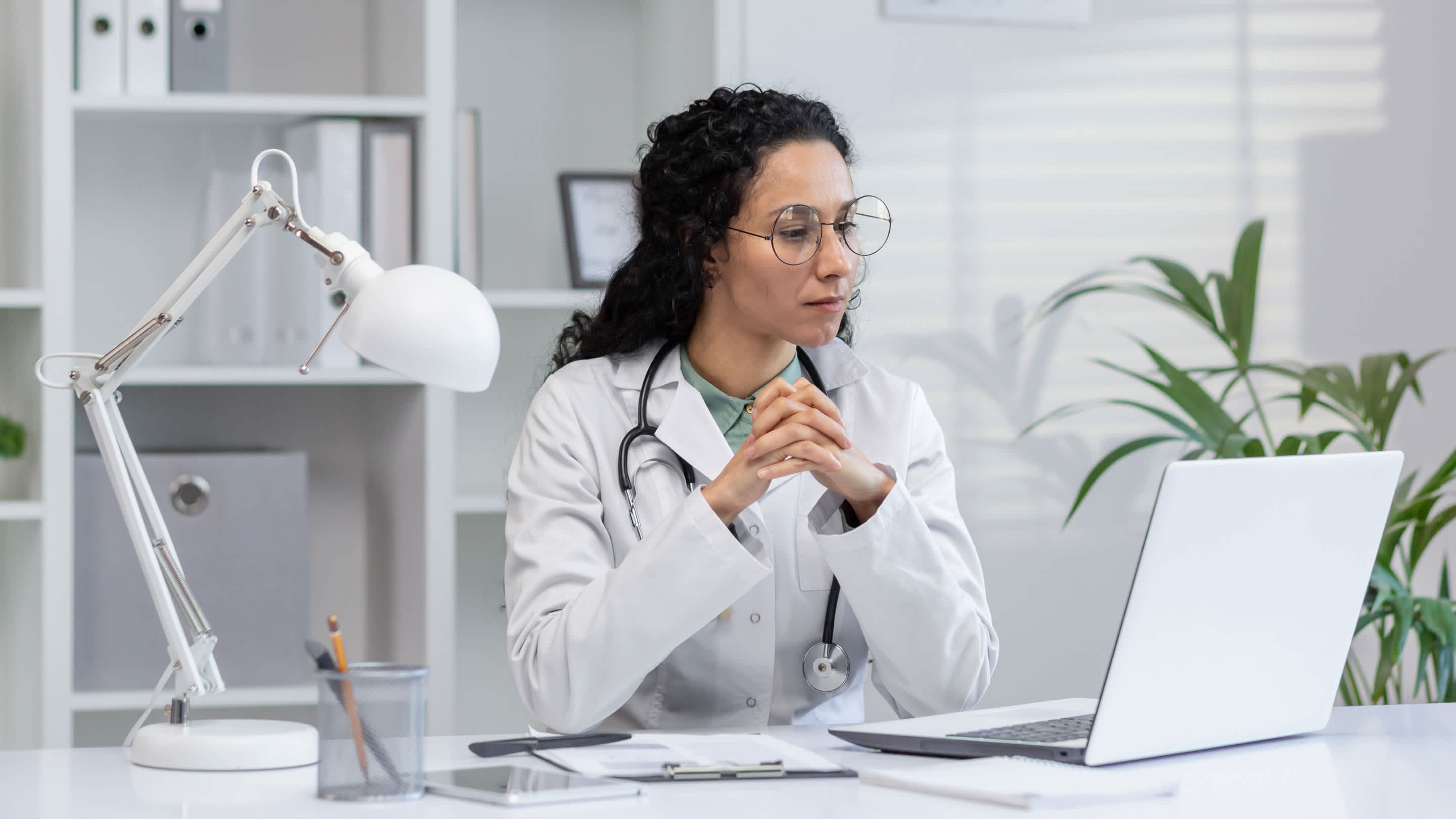 female doctor with glasses looking at her laptop