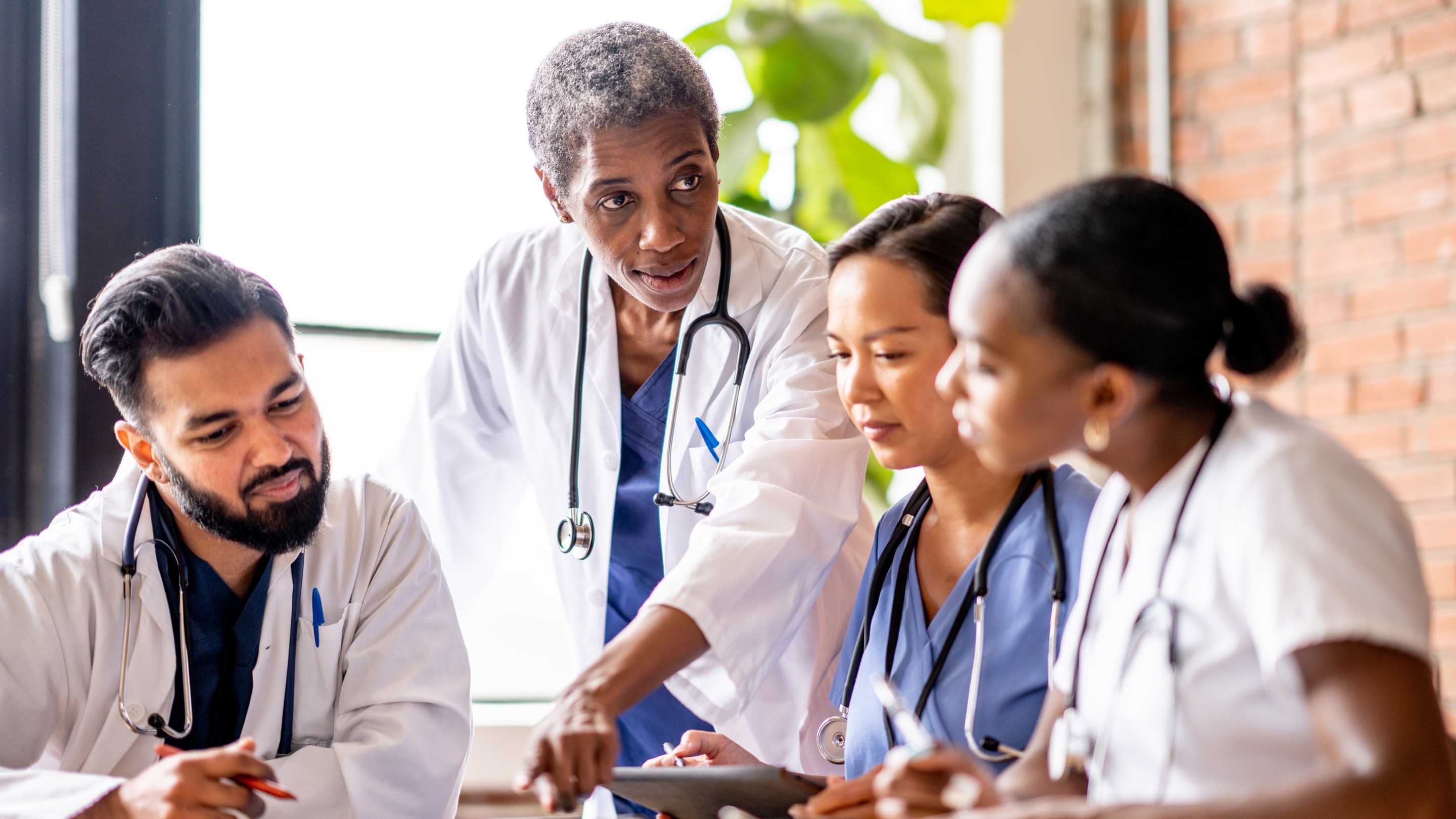 A group of multiethnic family physicians gathered around a table.