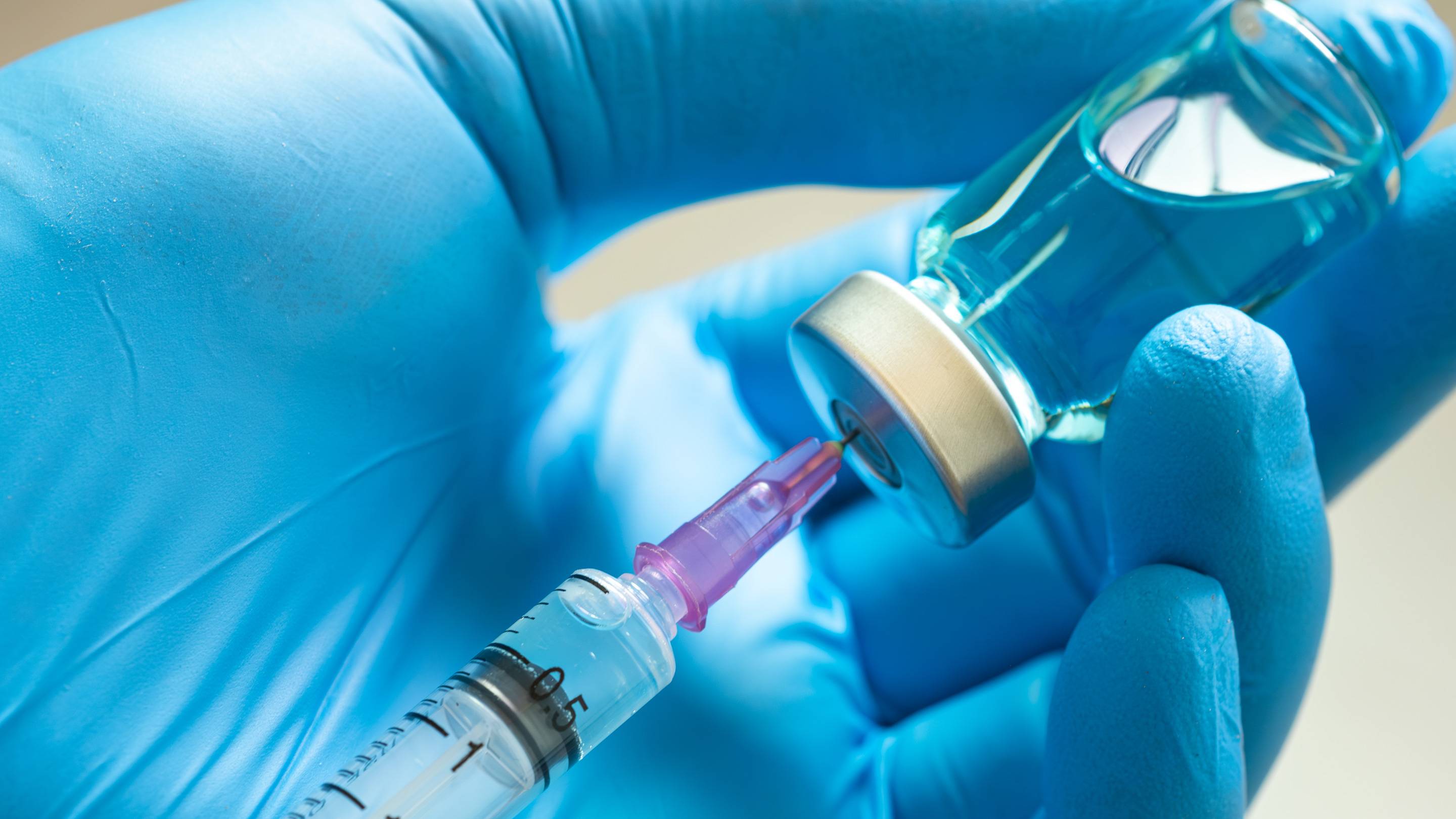 Close up of syringe and vaccine vial.