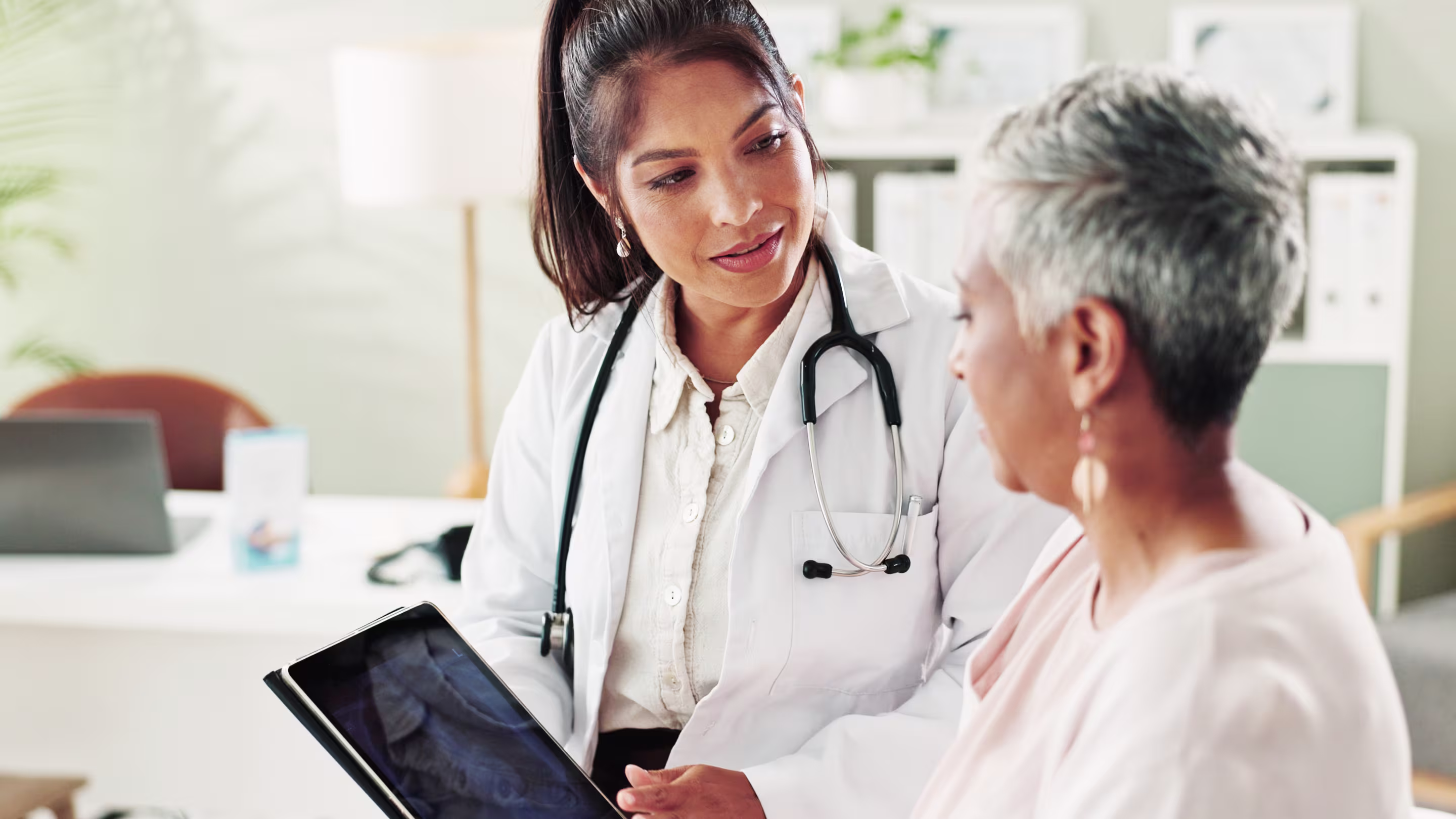 Older adult speaking with a physician during a routine visit.