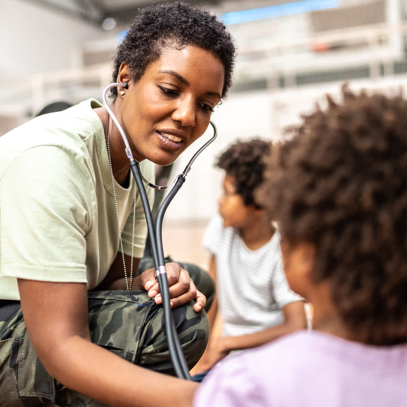 Image of a physician examining refugee children at a community center.