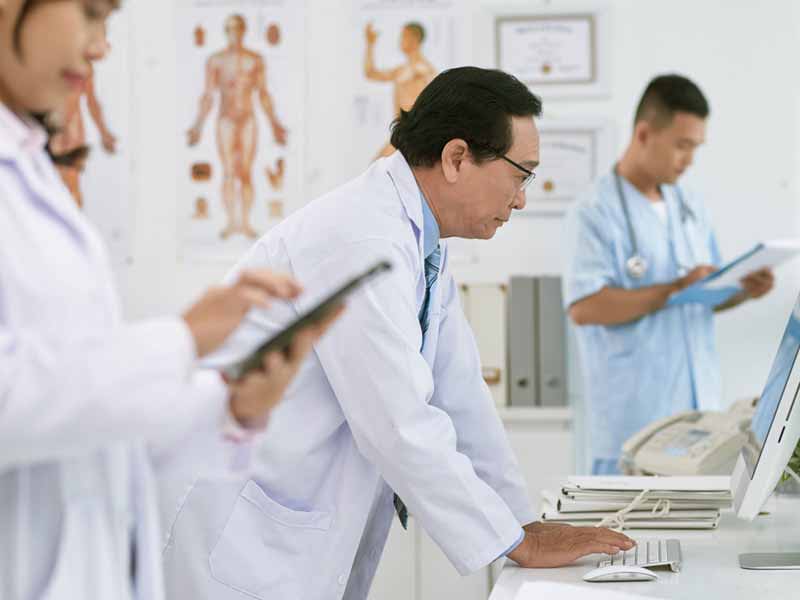 older physician looking at computer screen