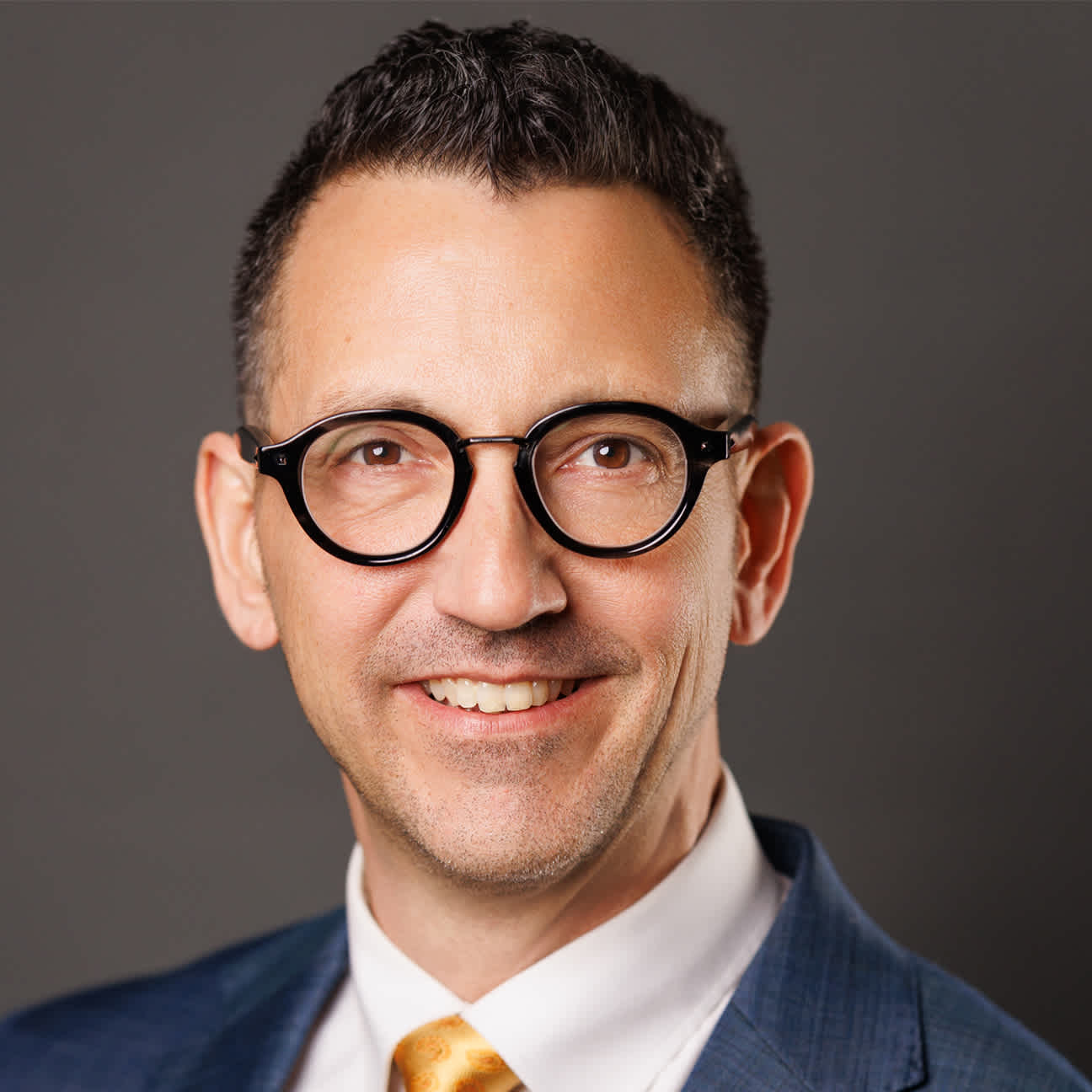 A smiling man with glasses.
