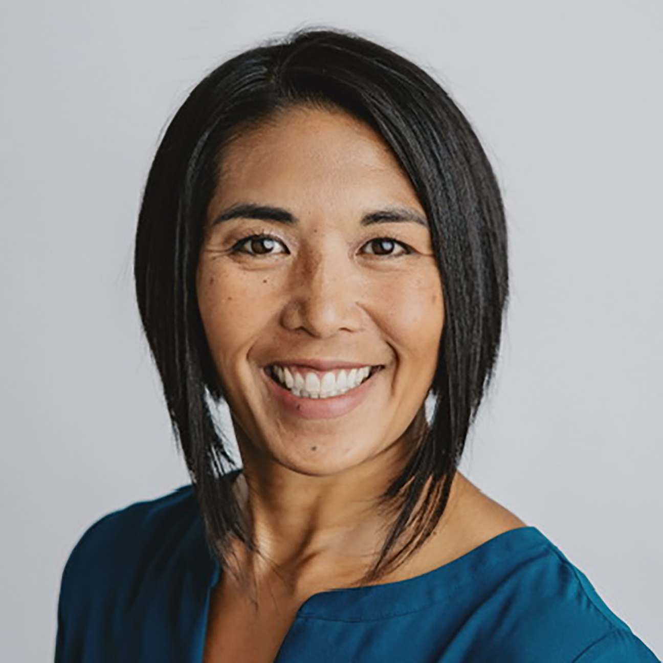 A studio portrait of Sarah Gerrish with a medium gray backdrop.