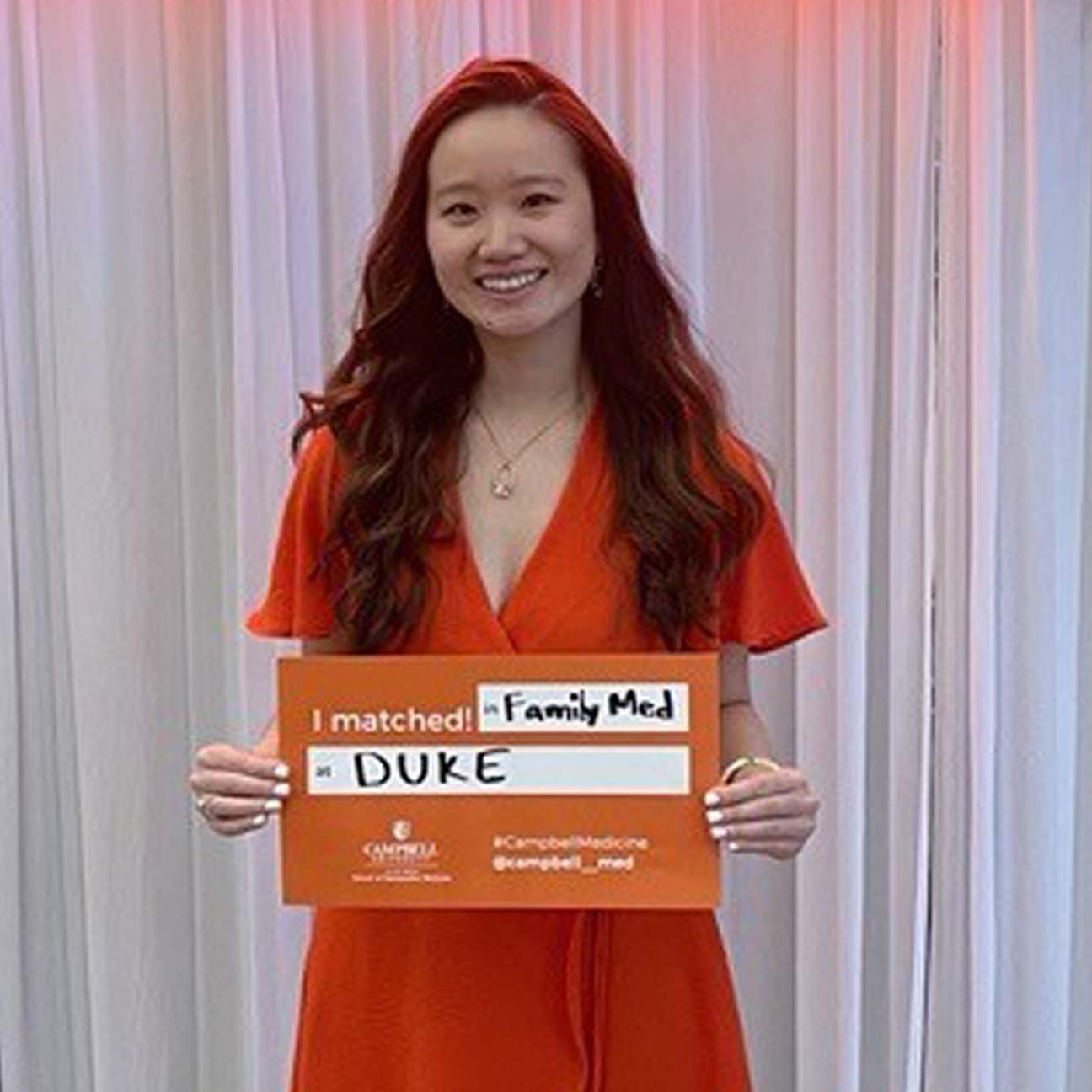 Colleen Yang hold up a sign showing where she matched on Match Day