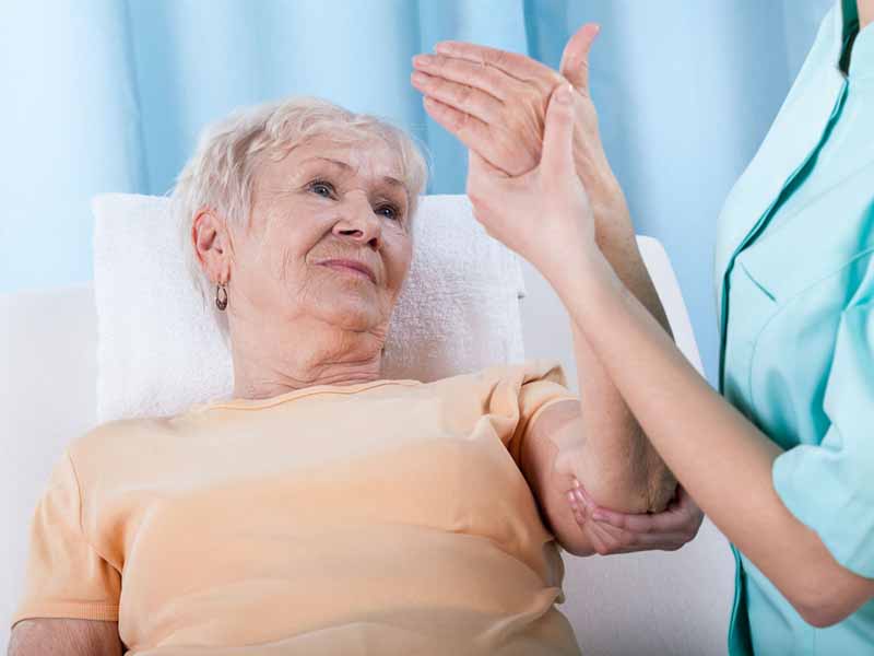 Clinician examining older woman's arm