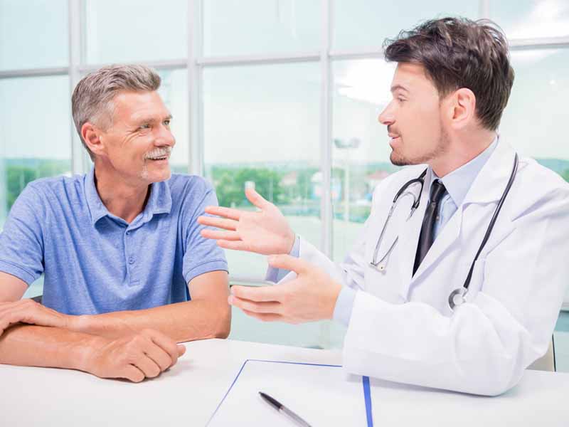 physician speaking with older male patient