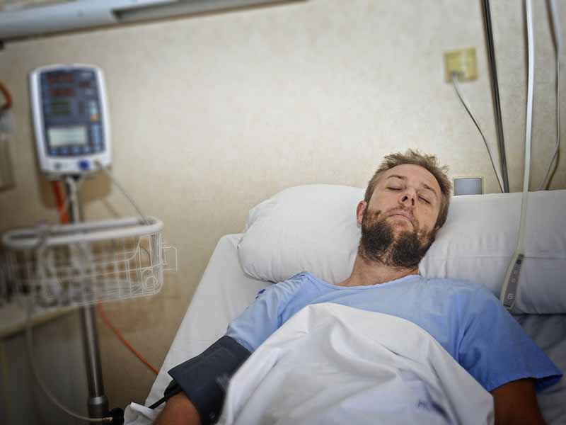 Man lying in hospital bed