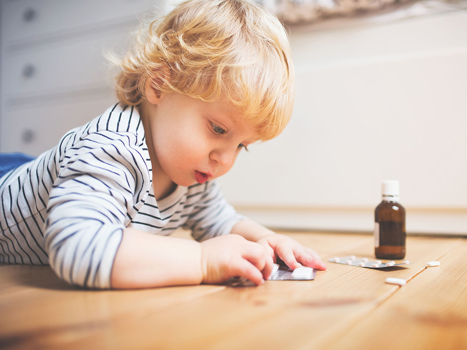 Young child playing with blister pack of pills