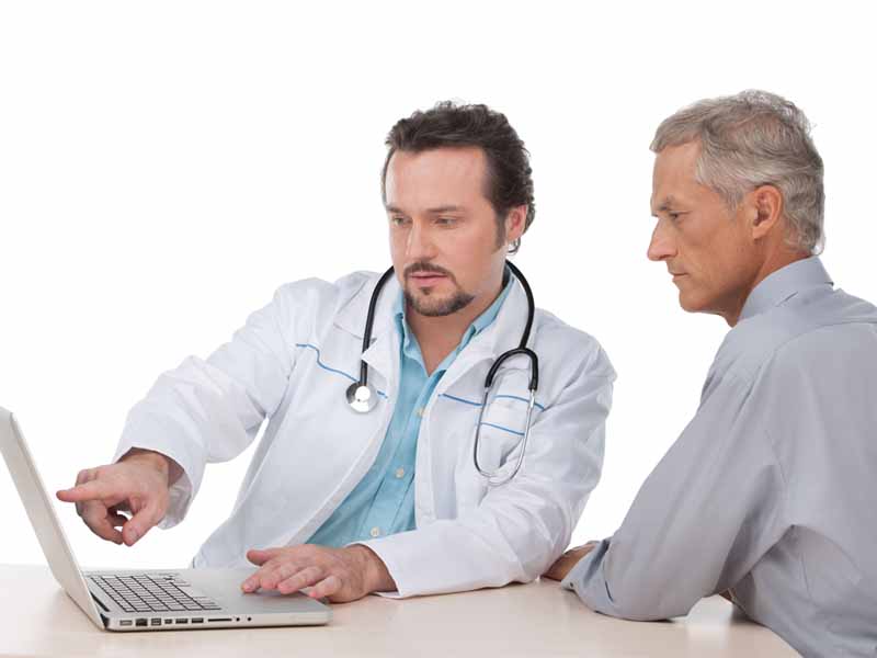 physician looking at test results on laptop with patient