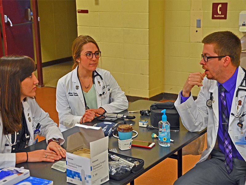 Three osteopathic medical students from A.T. Still University's Kirksville College of Osteopathic Medicine prepare to treat patients as part of a free health fair put on by Still Caring Health Connection-Volunteers in Medicine.