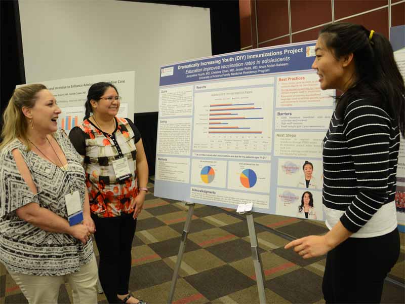 Arizona AFP staff member Christy Boring, left, joins poster award winners Jacqueline Huynh, M.D., center, and Christine Chan, M.D., of the University of Arizona Alvernon Family Medicine Residency in Tucson, in discussing their project to improve vaccination rates among adolescents. 