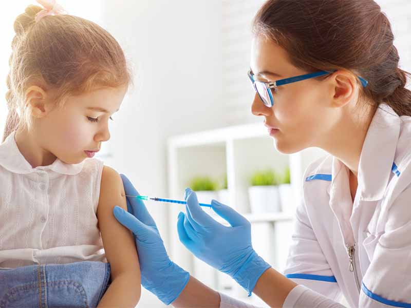 clinician vaccinating young girl