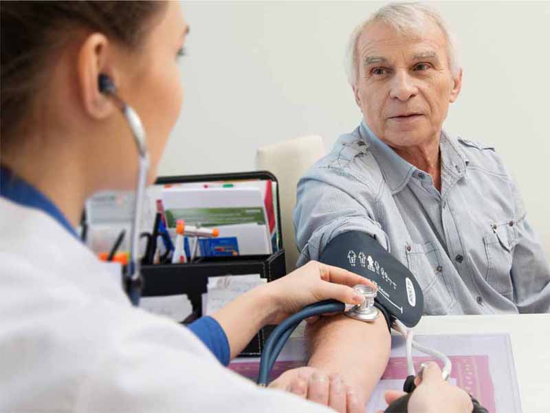 clinician taking older man's blood pressure