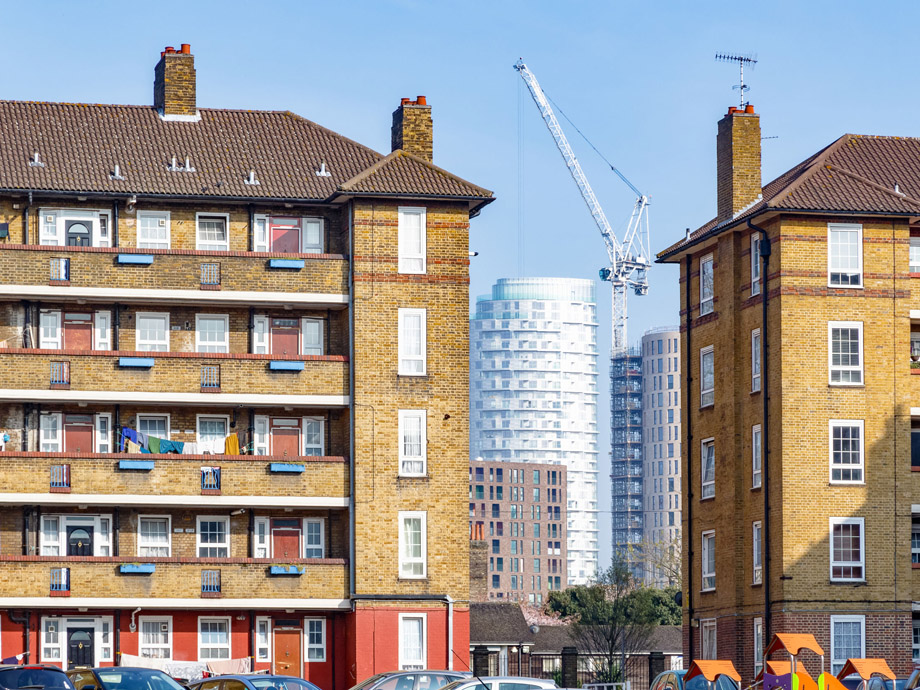 86580521 - council housing blocks contrasted with modern high-rise flats in the background