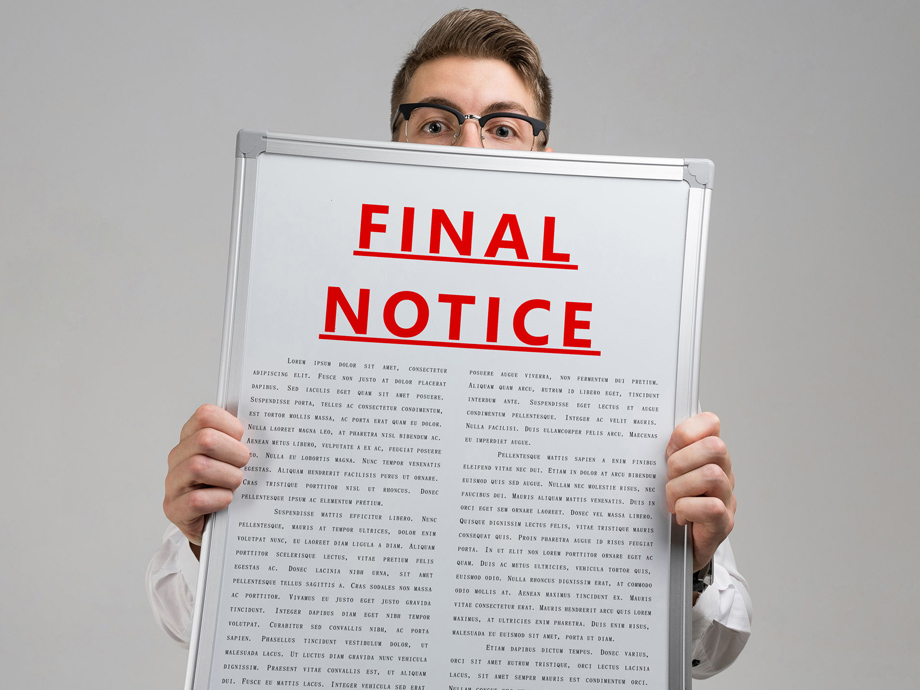 man in a shirt with a poster with a red inscription about final notice isolated in a bright Studio. Holding Invoice With Final Demand Notification. FINAL EXAM message on the card shown by a man