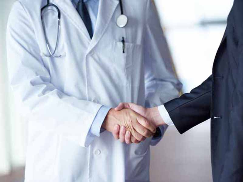 physician and businessman shaking hands