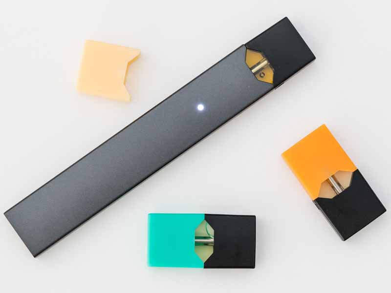 MORGANTOWN, WV - 25 AUGUST 2018: Juul e-cigarette or nicotine vapor stick and JUULpods on white background