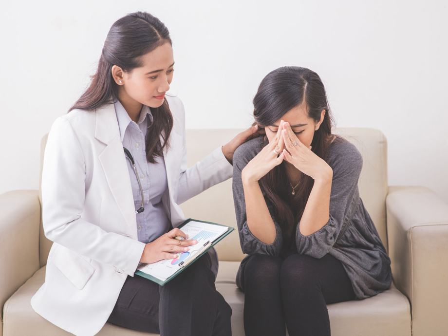 A portrait of Asian female patient crying while consulting her health problem with a female doctor
