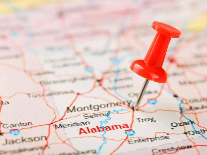 Red clerical needle on a map of USA, South Alabama and the capital Montgomery. Close up map of South Alabama with red tack, United States map pin USA