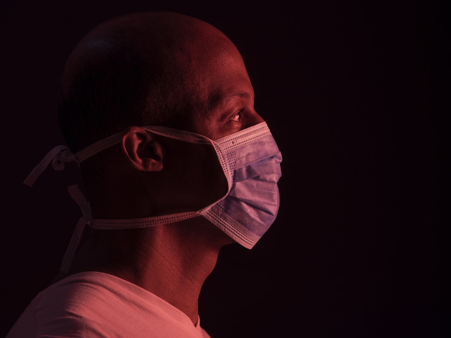 Coronavirus, side portrait of african american man with protective mask. COVID-19 concept. Studio shot on dark background with copyspace