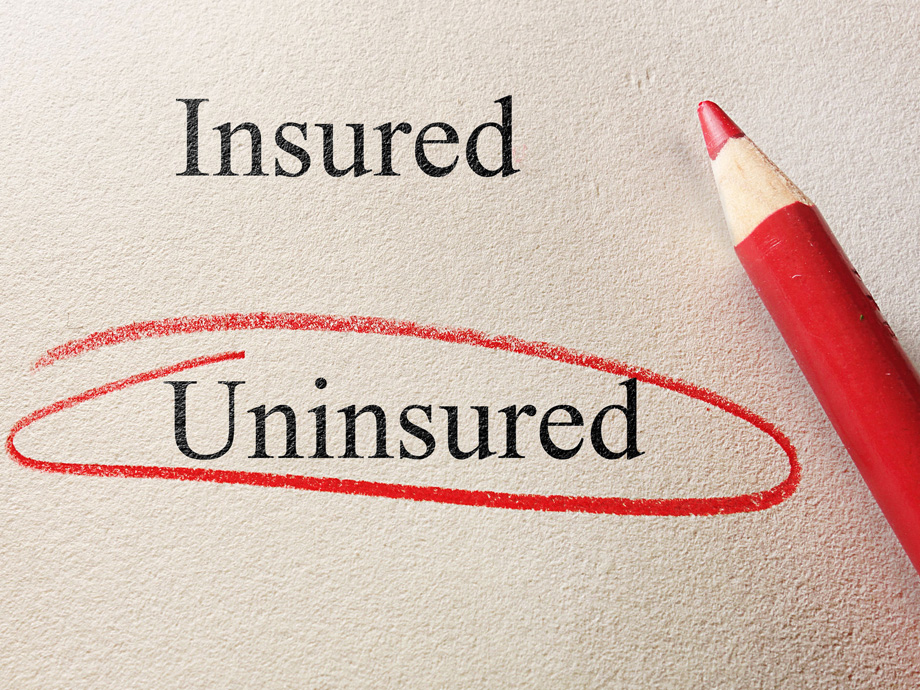 Uninsured circled, with Insured text and pencil on textured paper - lack of insurance concept