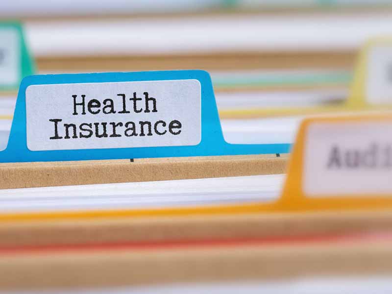 File folders with a tab labeled Health Insurance