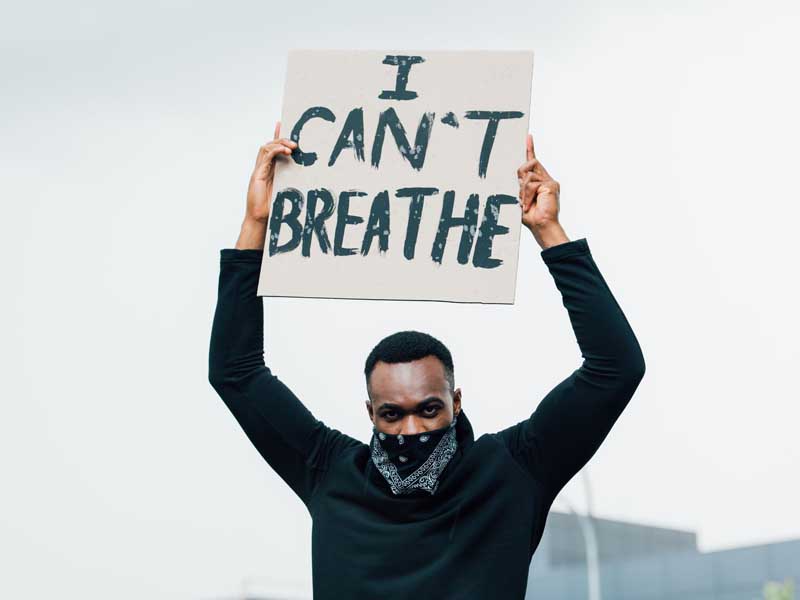 Man holding I can't breathe sign