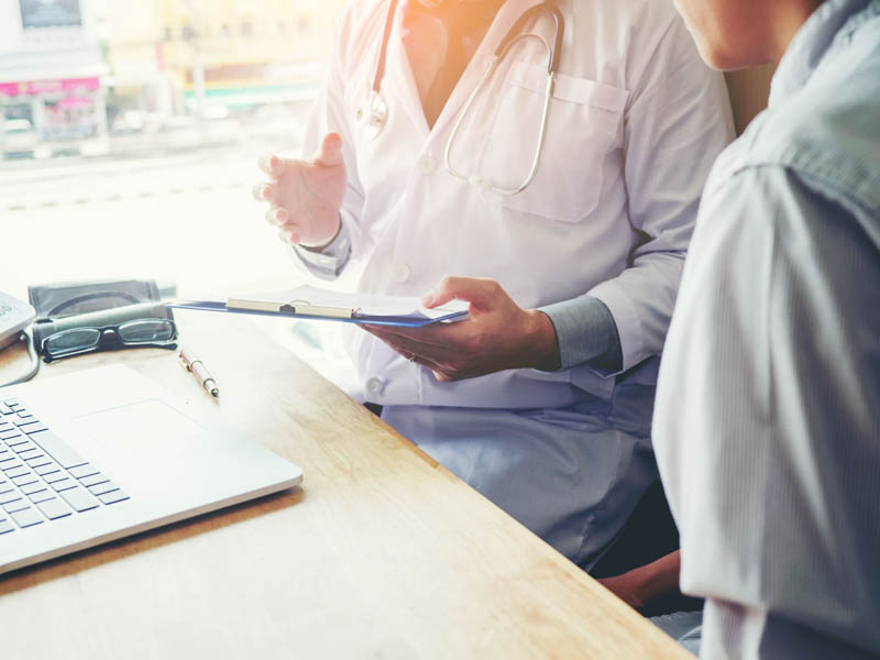 physician and patient talking near window