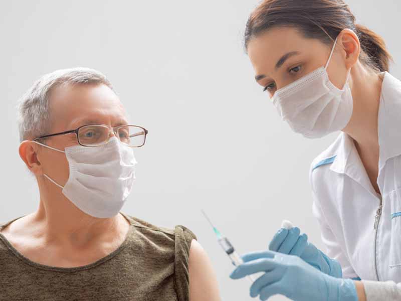 Doctor giving a senior woman vaccination
